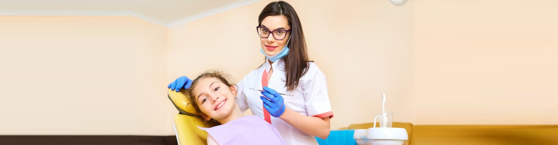 woman dentist treats your child`s teeth in the dental office